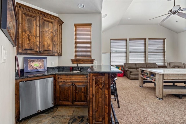 kitchen with fridge, open floor plan, vaulted ceiling, and a ceiling fan