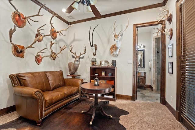 living area featuring crown molding, baseboards, a ceiling fan, and visible vents