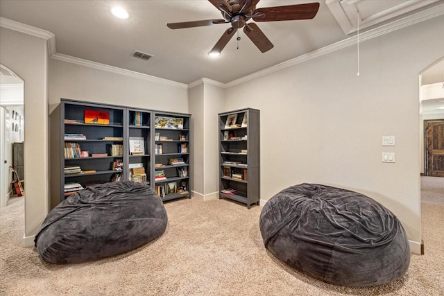 sitting room featuring crown molding, ceiling fan, carpet, attic access, and visible vents