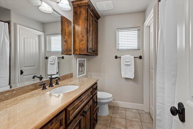bathroom featuring toilet, baseboards, tile patterned floors, and vanity