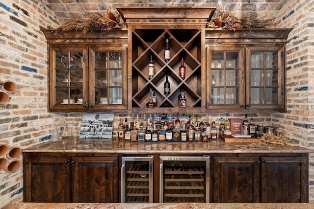 bar with beverage cooler, brick wall, and a bar