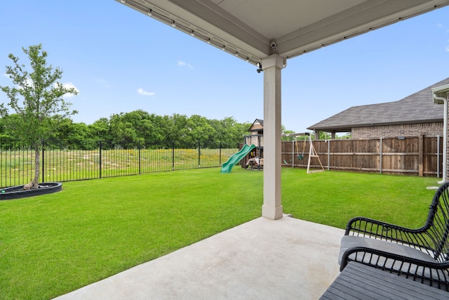 view of yard with a patio, a fenced backyard, and a playground