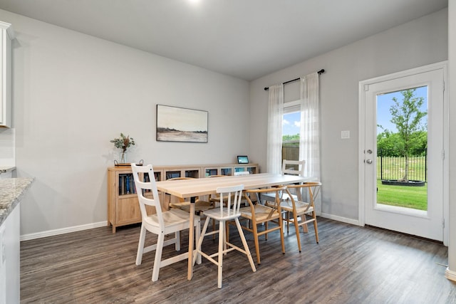 dining area with baseboards and dark wood-style flooring
