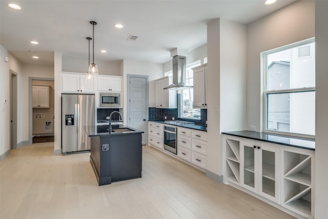kitchen featuring visible vents, decorative backsplash, dark countertops, island range hood, and appliances with stainless steel finishes