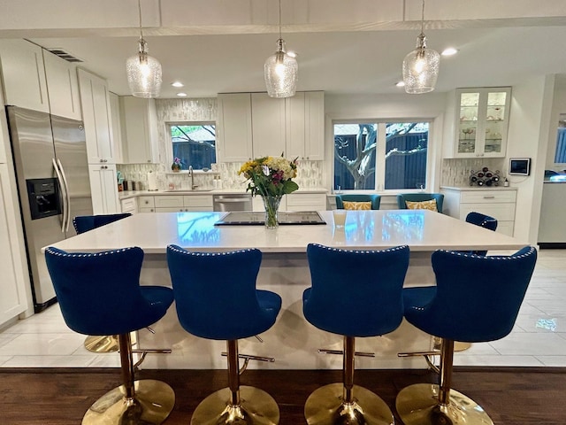 7449 Tophill Ln, Dallas, TX 75248 - kitchen with stainless steel appliances, decorative backsplash, white cabinetry, and recessed lighting
