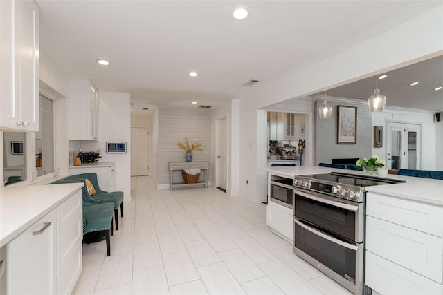 7449 Tophill Ln, Dallas, TX 75248 - kitchen featuring range with two ovens, white cabinets, light countertops, recessed lighting, and decorative light fixtures