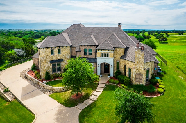 7101 Royal Birkdale Dr, Cleburne, TX 76033 - french provincial home featuring stone siding, a chimney, a shingled roof, and a front yard