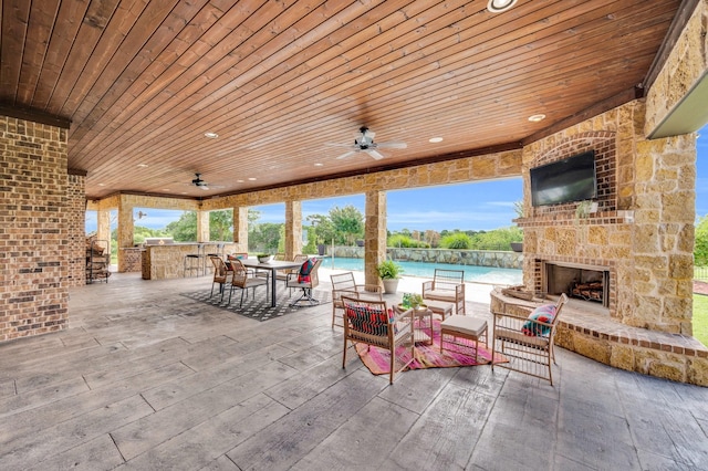 7101 Royal Birkdale Dr, Cleburne, TX 76033 - view of patio featuring a ceiling fan, an outdoor stone fireplace, an outdoor pool, and outdoor dining space