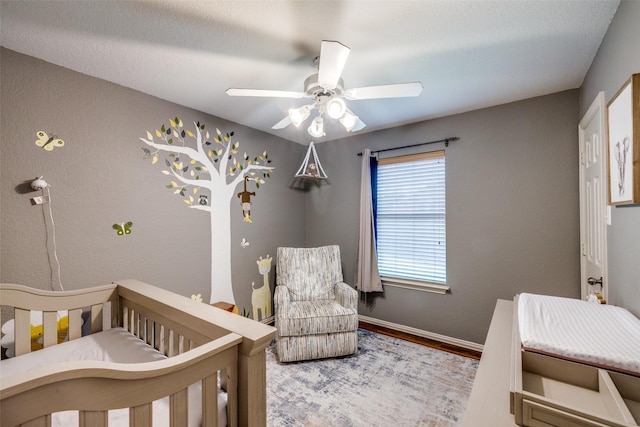 4604 Valleyview Dr, Mansfield, TX 76063 - bedroom featuring wood finished floors, baseboards, a ceiling fan, and a crib