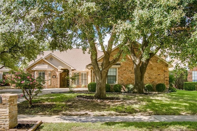 view of front of house featuring a front lawn and brick siding