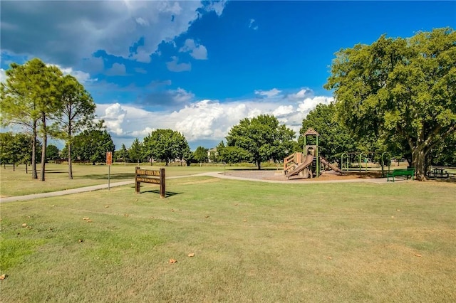 view of home's community with a lawn and playground community