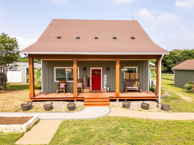 view of front of house featuring a front lawn, roof with shingles, and board and batten siding