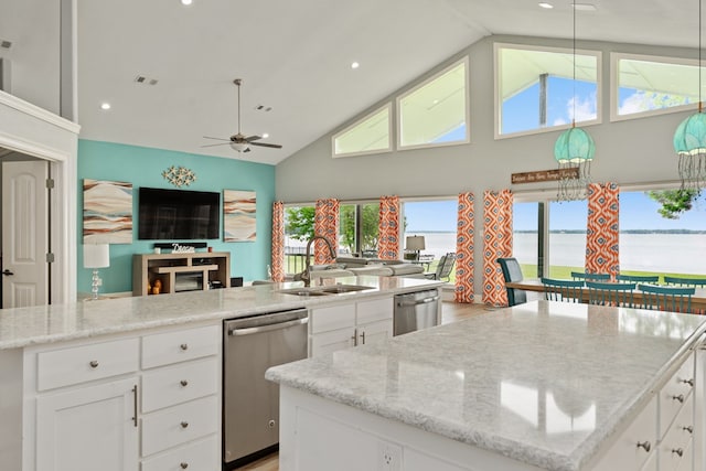 kitchen with stainless steel dishwasher, open floor plan, a sink, and a center island