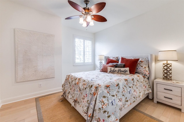 bedroom featuring light wood-type flooring, a ceiling fan, and baseboards