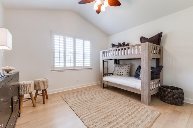 bedroom with baseboards, a ceiling fan, light wood-style flooring, and vaulted ceiling