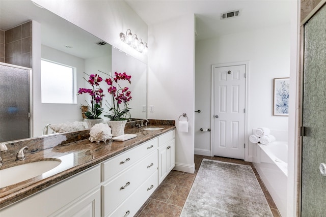 bathroom featuring visible vents, a sink, and a stall shower