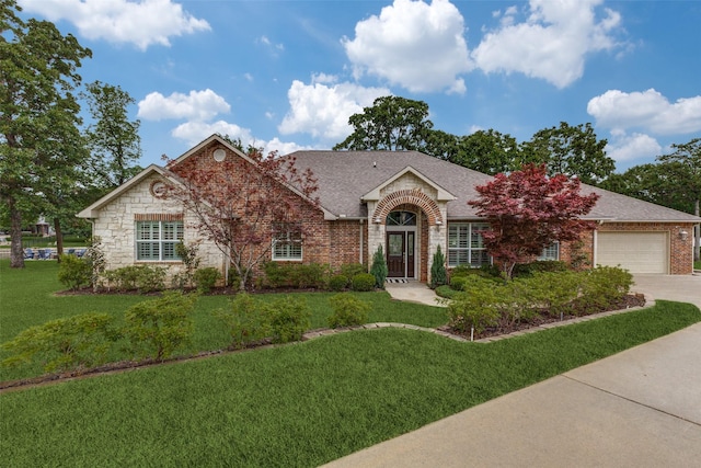 single story home with concrete driveway, brick siding, a shingled roof, and a front lawn