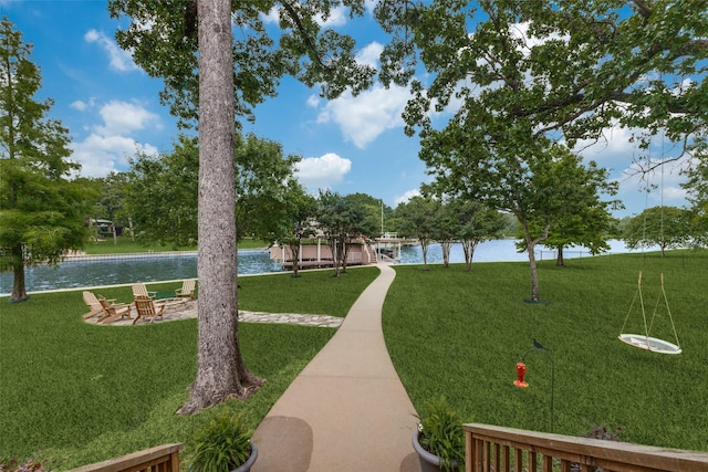 view of property's community with a lawn and a water view