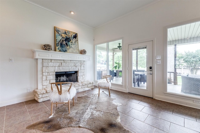living room with crown molding, baseboards, tile patterned flooring, and a fireplace