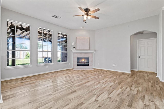 61 Sonora Dr, Trophy Club, TX 76262 - unfurnished living room with visible vents, a ceiling fan, baseboards, arched walkways, and light wood-style flooring