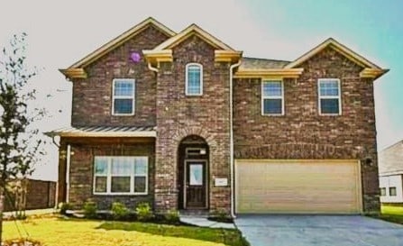 view of front of home featuring a garage, driveway, and a front lawn