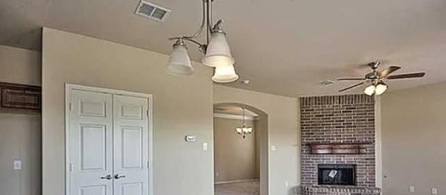 3117 Burwood Ln, Royse City, TX 75189 - unfurnished living room featuring arched walkways, ceiling fan, and a fireplace