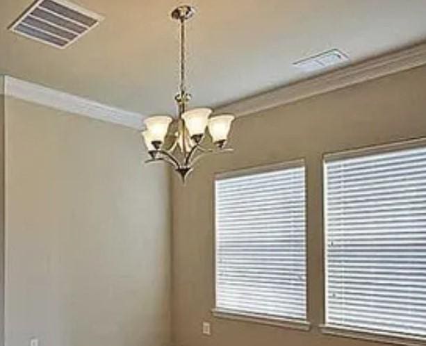 interior space with crown molding, a notable chandelier, and visible vents