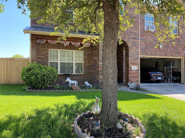 view of front facade with brick siding, a garage, fence, and a front yard