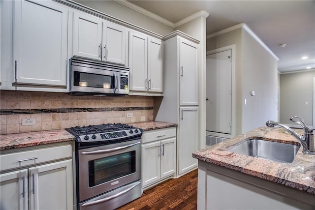 kitchen with dark wood-style flooring, crown molding, a sink, stainless steel appliances, and recessed lighting