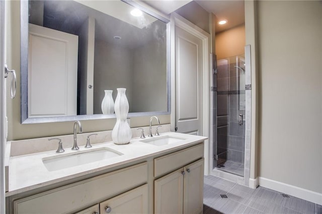 full bathroom featuring a sink, tile patterned flooring, a shower stall, and double vanity