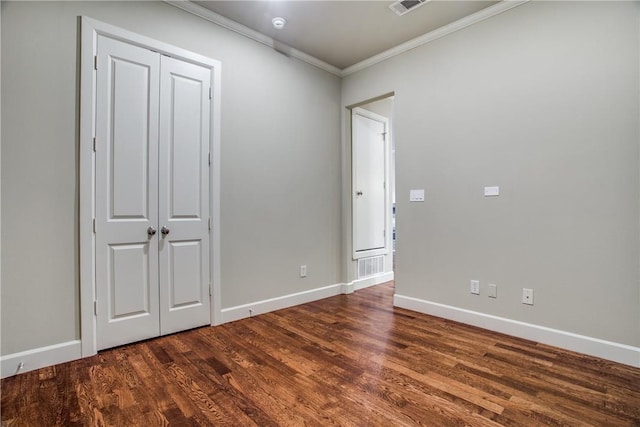 unfurnished bedroom with baseboards, ornamental molding, dark wood-style flooring, and visible vents