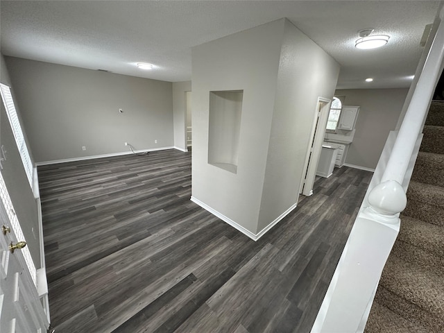 2129 San Simeon Dr, Mesquite, TX 75181 - corridor with a textured ceiling, baseboards, stairway, and dark wood-type flooring