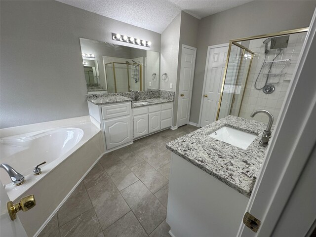 2129 San Simeon Dr, Mesquite, TX 75181 - bathroom with a sink, a textured ceiling, two vanities, a garden tub, and a stall shower