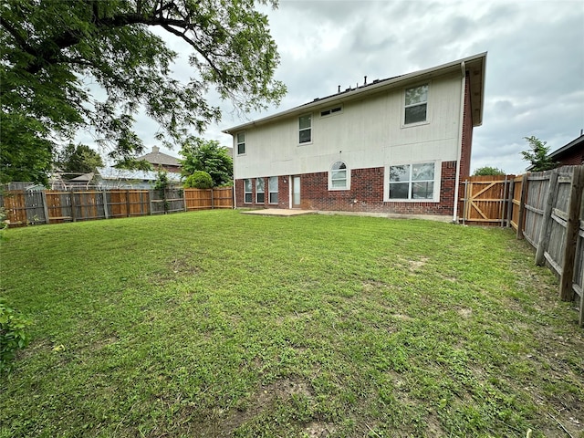 2129 San Simeon Dr, Mesquite, TX 75181 - rear view of house with brick siding, a fenced backyard, and a yard