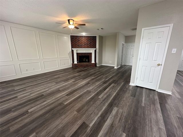 2129 San Simeon Dr, Mesquite, TX 75181 - unfurnished living room with ceiling fan, dark wood-style flooring, a textured ceiling, a fireplace, and baseboards