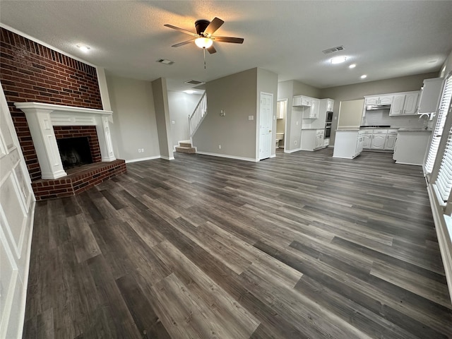 2129 San Simeon Dr, Mesquite, TX 75181 - unfurnished living room featuring visible vents, a ceiling fan, stairs, and dark wood-style floors