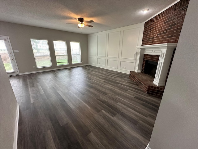 2129 San Simeon Dr, Mesquite, TX 75181 - unfurnished living room with ceiling fan, a fireplace, a textured ceiling, and dark wood-type flooring
