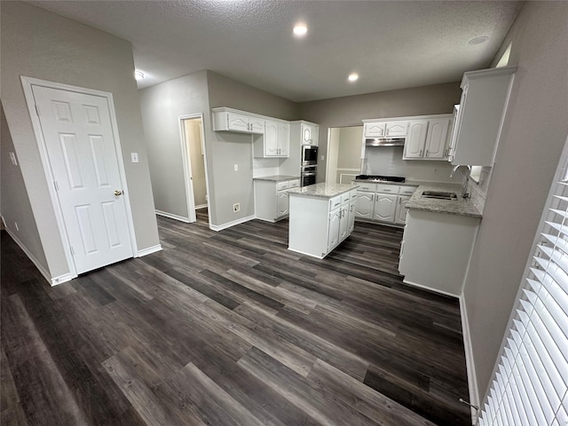 2129 San Simeon Dr, Mesquite, TX 75181 - kitchen with gas cooktop, a kitchen island, a sink, under cabinet range hood, and white cabinetry