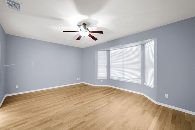 unfurnished room with light wood-style floors, baseboards, ceiling fan, and visible vents