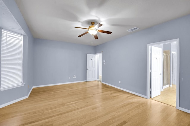 unfurnished bedroom featuring ceiling fan, baseboards, visible vents, and light wood-style flooring