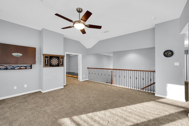 additional living space featuring a ceiling fan, visible vents, carpet floors, baseboards, and lofted ceiling