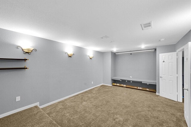 finished basement featuring baseboards, visible vents, and carpet