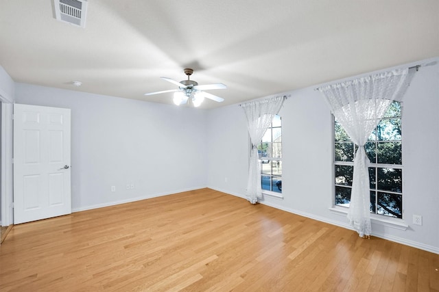 spare room with a ceiling fan, baseboards, visible vents, and light wood-type flooring