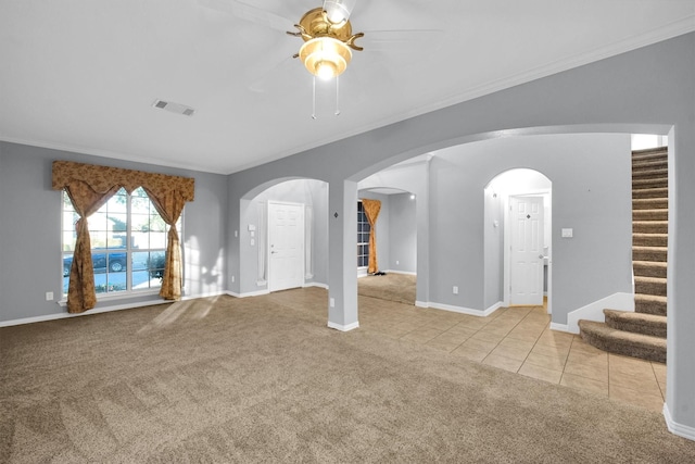 unfurnished living room featuring visible vents, carpet floors, stairs, a ceiling fan, and arched walkways