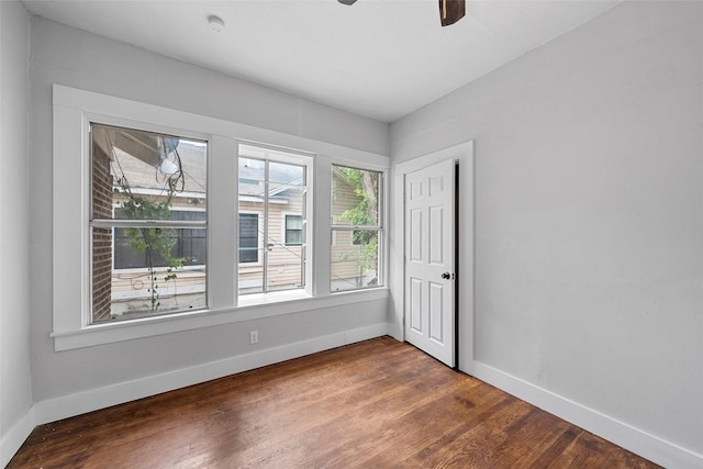 spare room with baseboards, a ceiling fan, and wood finished floors