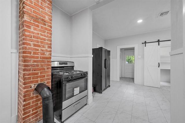 kitchen featuring a barn door, gas stove, marble finish floor, freestanding refrigerator, and visible vents