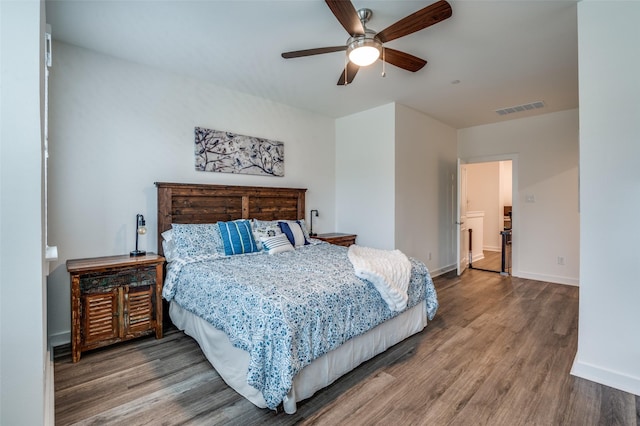 bedroom featuring ceiling fan, baseboards, visible vents, and wood finished floors