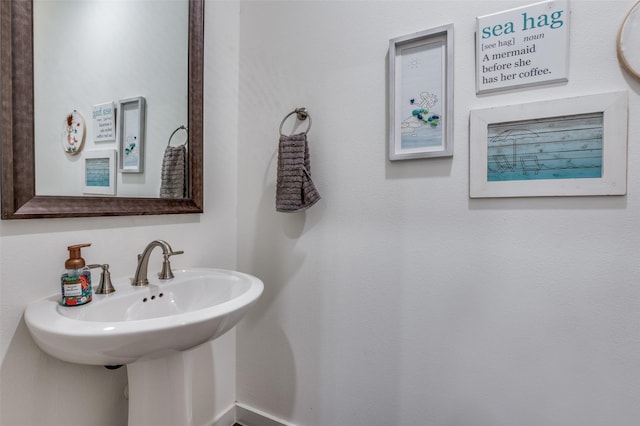 bathroom with a sink and baseboards
