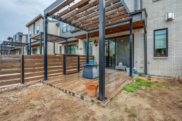 exterior space featuring a deck, fence, and a pergola