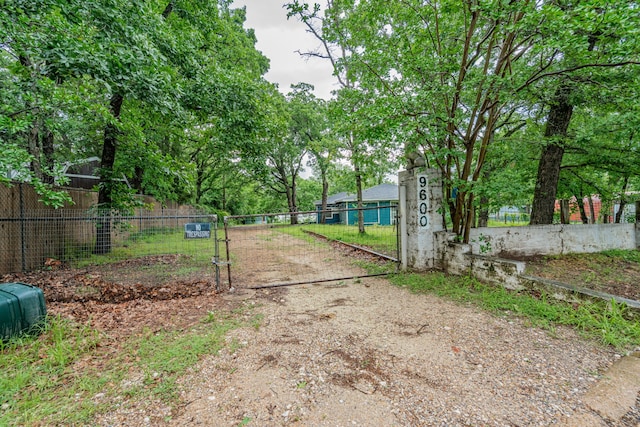 view of road featuring a gated entry and dirt driveway
